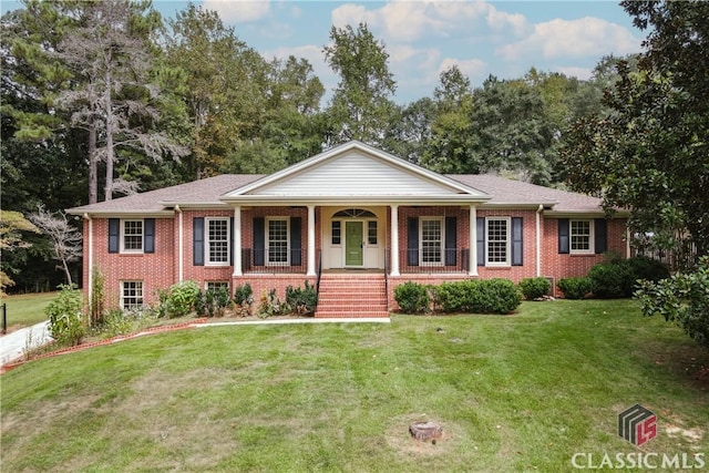 ranch-style home featuring brick siding, a porch, and a front yard