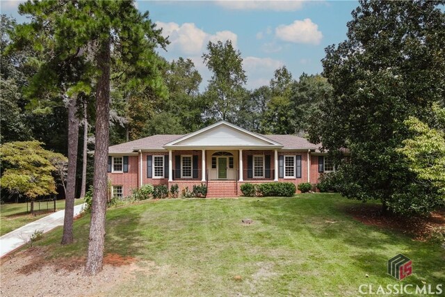 ranch-style home with a front lawn and covered porch