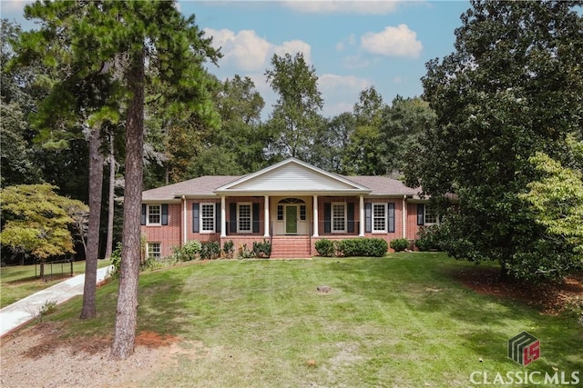 view of front of property with brick siding, covered porch, and a front yard