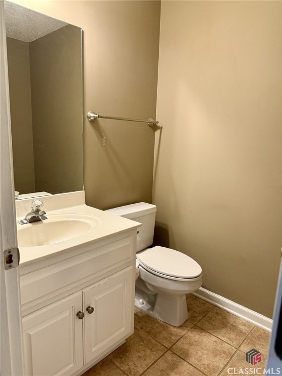 bathroom with vanity, toilet, and tile patterned flooring