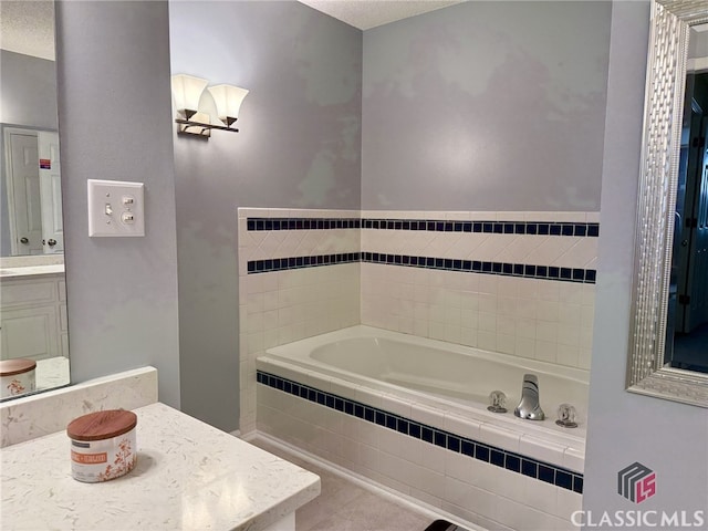 bathroom with vanity, tiled bath, and a textured ceiling