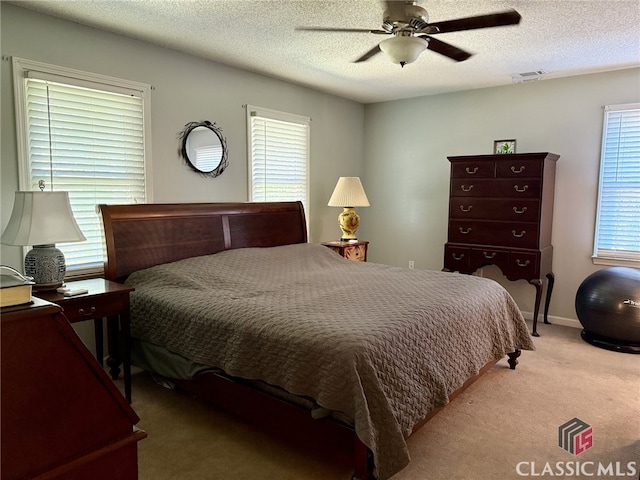 bedroom featuring a textured ceiling, multiple windows, and ceiling fan