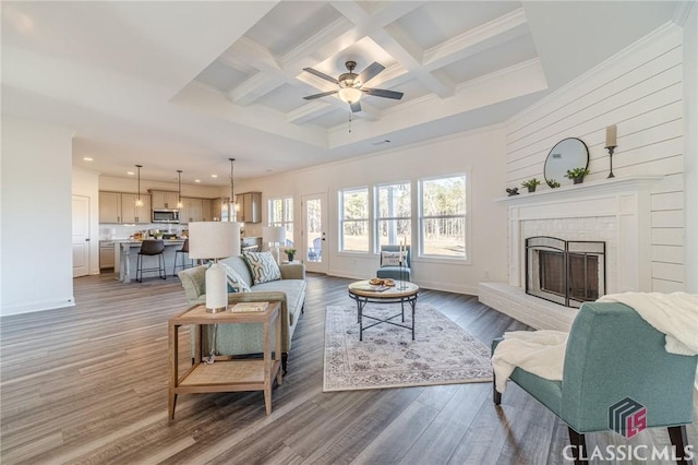 living room featuring ceiling fan, a fireplace, beamed ceiling, coffered ceiling, and hardwood / wood-style flooring