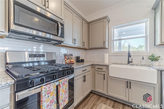 kitchen with stainless steel appliances, tasteful backsplash, dark hardwood / wood-style flooring, crown molding, and sink