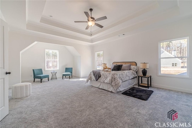 carpeted bedroom with ceiling fan, crown molding, and a tray ceiling