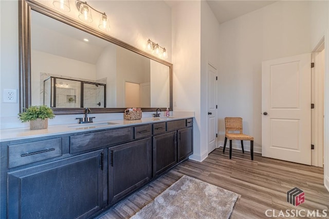 bathroom featuring vanity, lofted ceiling, hardwood / wood-style flooring, and walk in shower