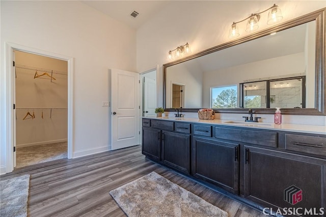 bathroom with walk in shower, wood-type flooring, and vanity