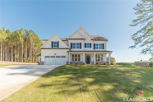 view of front of property featuring a front lawn, a garage, and a porch