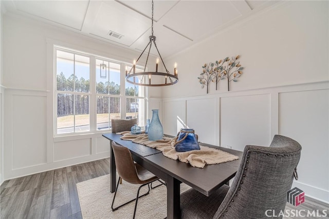 dining room with coffered ceiling, crown molding, hardwood / wood-style flooring, and a notable chandelier