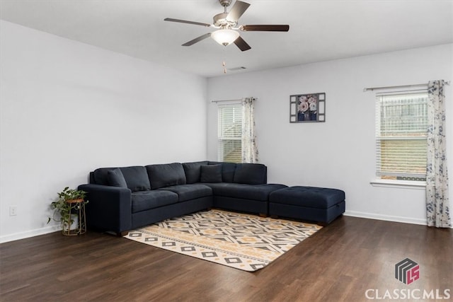 living room featuring ceiling fan and dark wood-type flooring