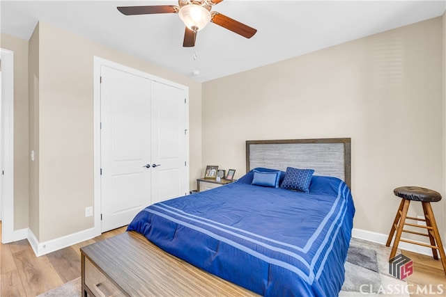 bedroom featuring light hardwood / wood-style flooring, ceiling fan, and a closet