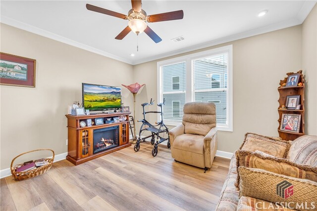 sitting room featuring ceiling fan, light hardwood / wood-style floors, and crown molding