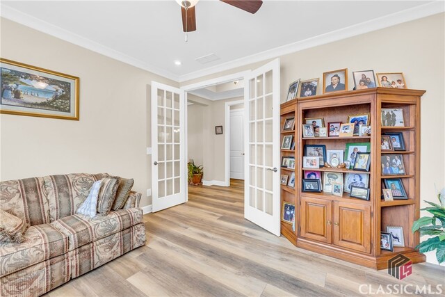 living room with ceiling fan, ornamental molding, light hardwood / wood-style floors, and french doors