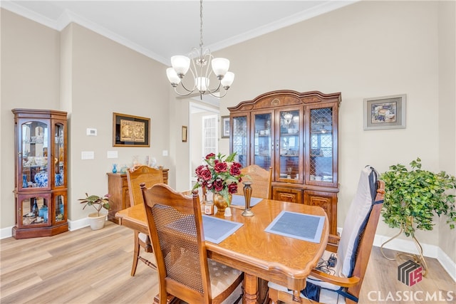 dining area with light hardwood / wood-style flooring, ornamental molding, and a chandelier