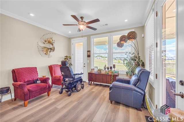 sitting room featuring ceiling fan, ornamental molding, and light hardwood / wood-style flooring