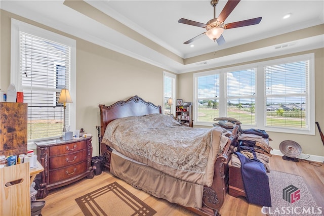 bedroom with light wood-type flooring, multiple windows, crown molding, and ceiling fan