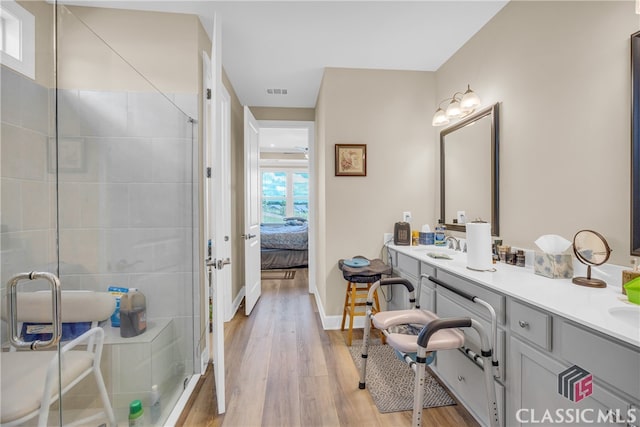 bathroom featuring vanity, wood-type flooring, and a shower with shower door