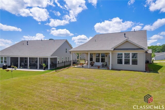 back of house with a sunroom, a yard, and a patio area