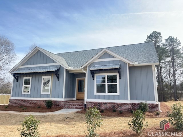 view of front of house with board and batten siding and roof with shingles