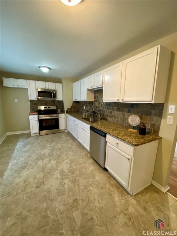 kitchen featuring sink, white cabinets, dark stone counters, and appliances with stainless steel finishes