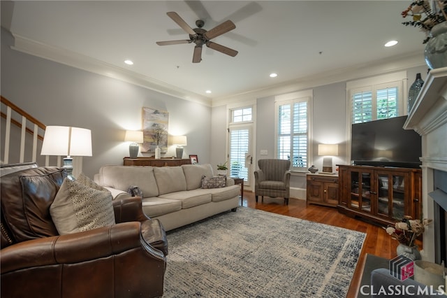 living room with ornamental molding, ceiling fan, and dark hardwood / wood-style floors