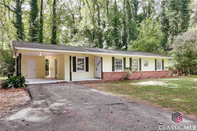 ranch-style home featuring a carport and a front yard