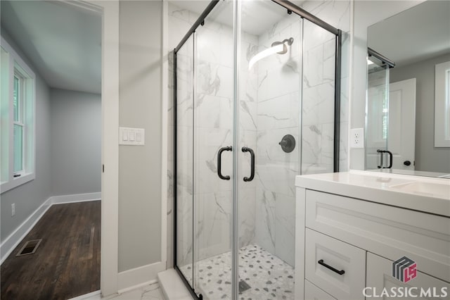 bathroom featuring an enclosed shower, vanity, and hardwood / wood-style flooring