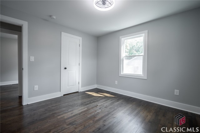 empty room with dark hardwood / wood-style flooring