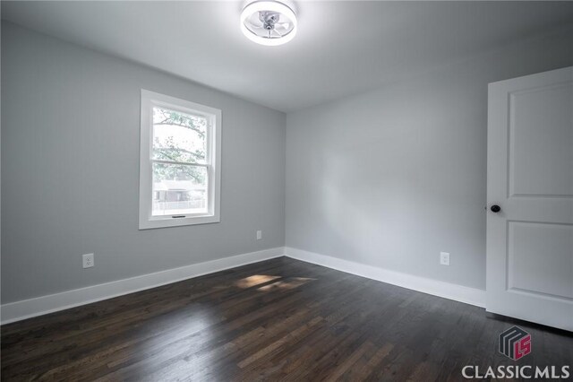 spare room featuring dark wood-type flooring