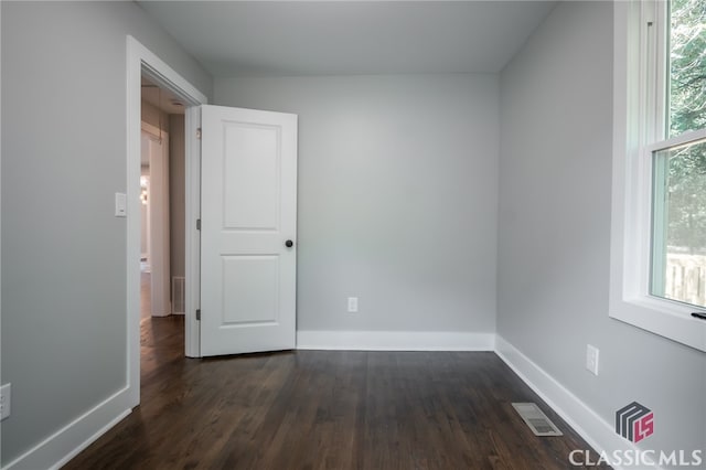 spare room with dark wood-type flooring