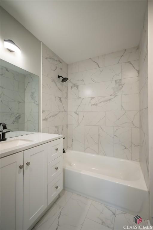 bathroom featuring tiled shower / bath combo and vanity