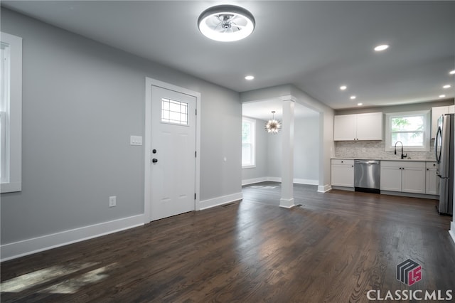 entrance foyer with a notable chandelier, dark hardwood / wood-style floors, and sink