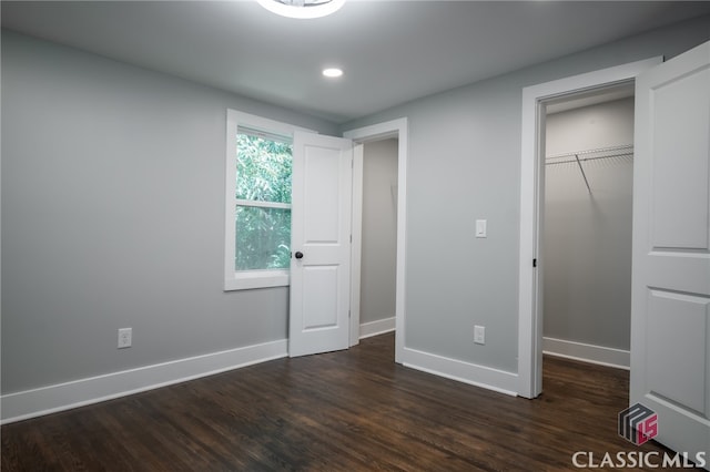 unfurnished bedroom featuring a closet and dark hardwood / wood-style flooring