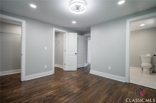 unfurnished bedroom with dark wood-type flooring and ensuite bathroom