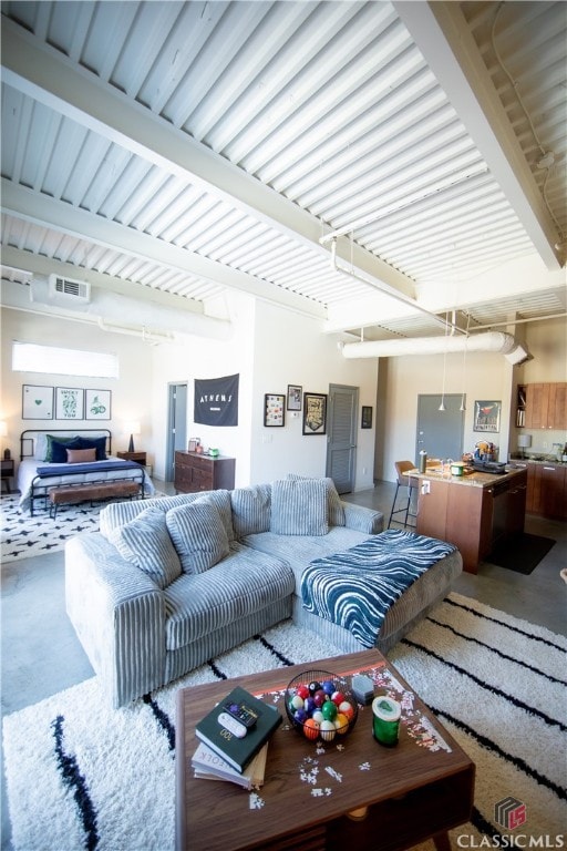 living room featuring concrete floors, beam ceiling, and a fireplace