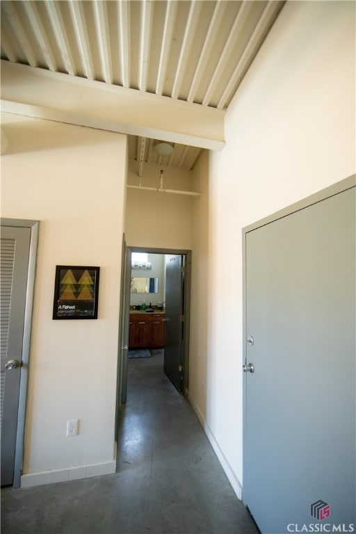 hallway with a high ceiling and beam ceiling