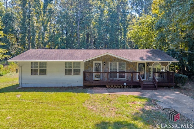 ranch-style home featuring covered porch and a front lawn