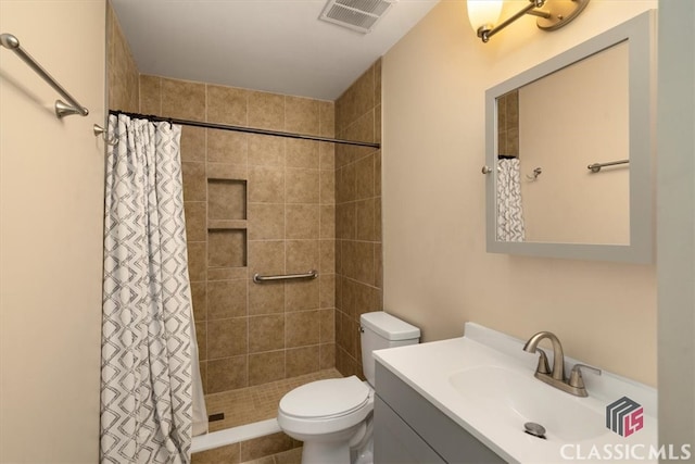 bathroom featuring curtained shower, tile patterned flooring, vanity, and toilet