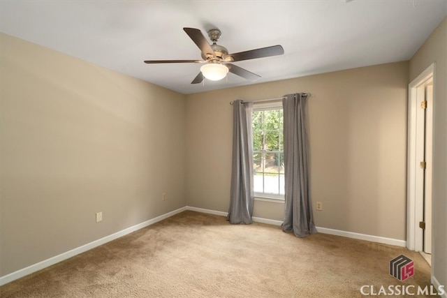 spare room featuring ceiling fan and light carpet