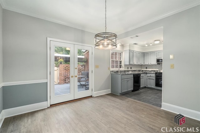 kitchen featuring hardwood / wood-style floors, backsplash, black appliances, gray cabinets, and decorative light fixtures