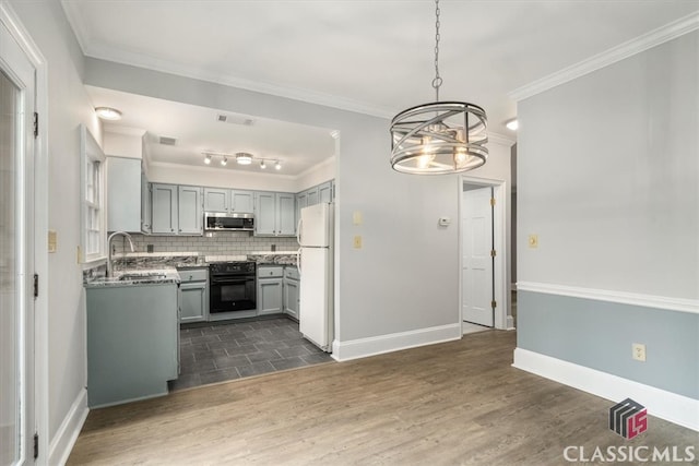 kitchen featuring sink, black stove, dark wood-type flooring, a notable chandelier, and white refrigerator