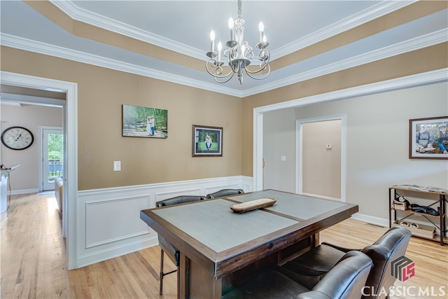 dining area featuring an inviting chandelier, light hardwood / wood-style flooring, and ornamental molding