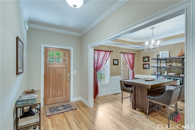 foyer entrance with ornamental molding, light hardwood / wood-style flooring, and plenty of natural light