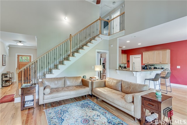 living room with crown molding and light hardwood / wood-style floors