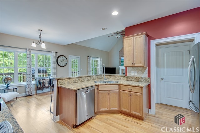 kitchen with hanging light fixtures, sink, stainless steel appliances, and plenty of natural light