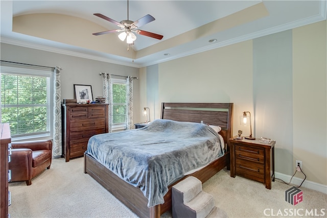 bedroom featuring a raised ceiling, ornamental molding, light carpet, and ceiling fan