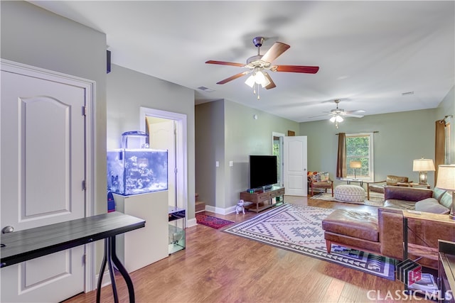 living room with ceiling fan and light hardwood / wood-style flooring