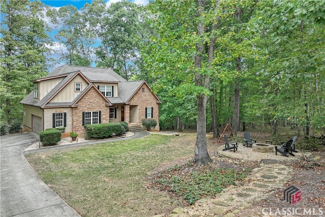 view of front facade with a front yard, an outdoor fire pit, and a garage