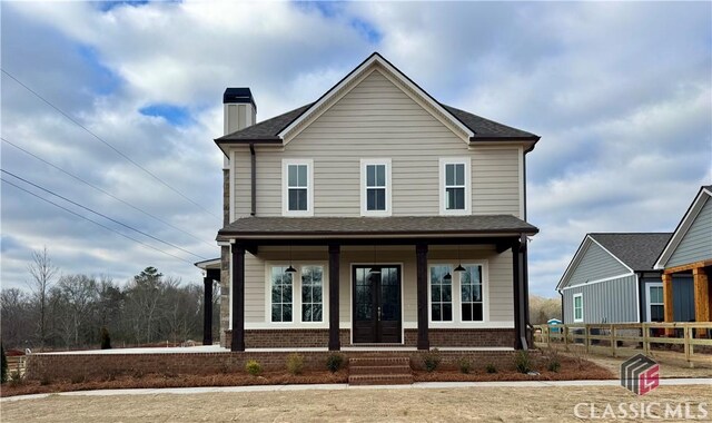 view of front of property with covered porch and a front lawn