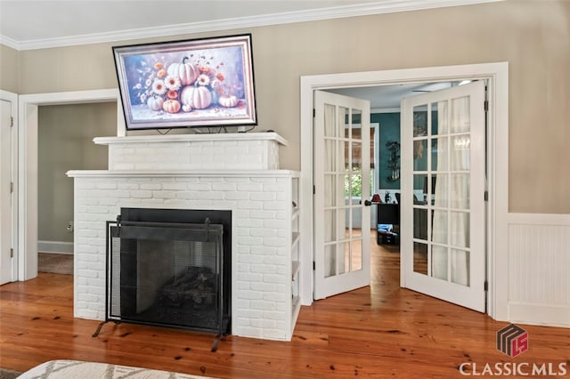 room details featuring ornamental molding, hardwood / wood-style flooring, a fireplace, and french doors